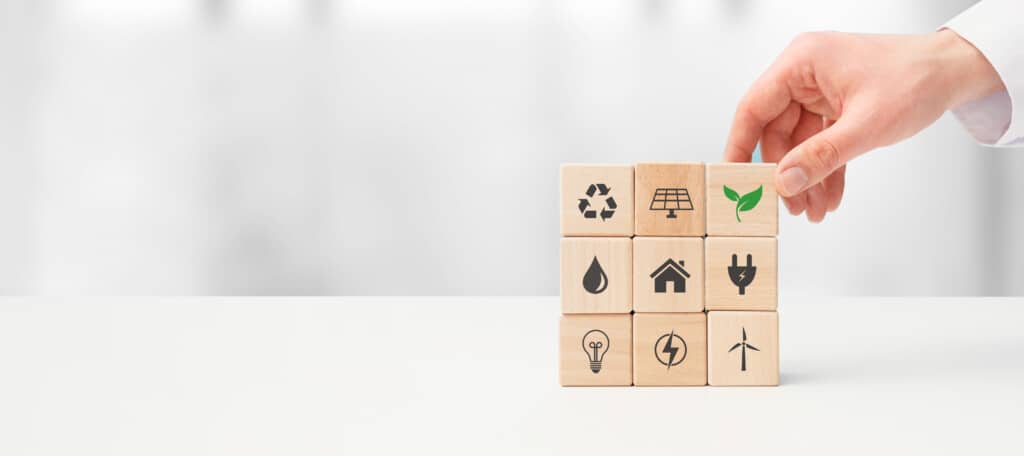 blocos de madeira empilhados com símbolos de práticas relacionadas com sustentabilidade