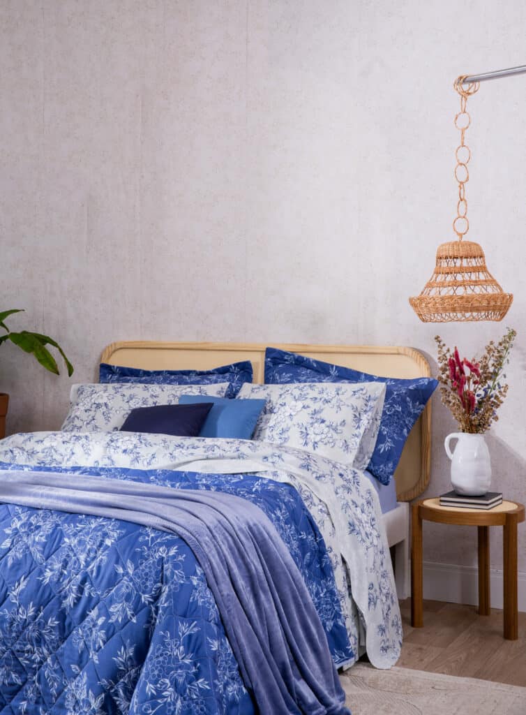 uma cama azul que trás um mix de estampas bonito